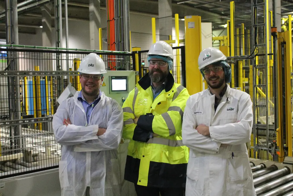 Kwinten Cantraine de Pilz avec Stefaan Temperman et Karel Osstyn de Cargill devant la machine d’emballage
