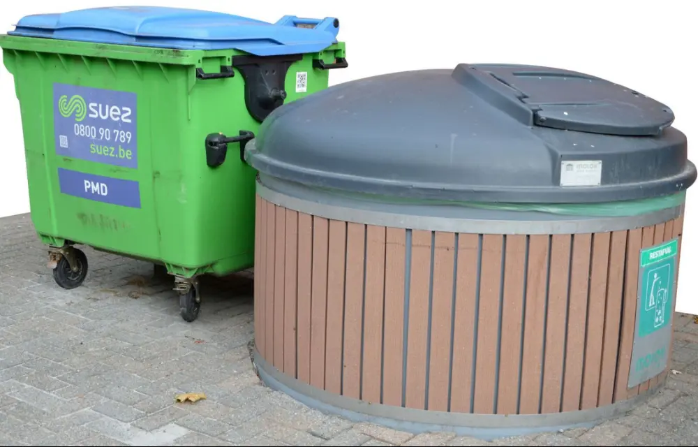 Le container avec le couvercle bleu destiné aux PMC doit être disposé à côté du container à déchets résiduels. Ainsi, les deux containers sont identifiés en tant que tels par les utilisateurs. Ici, le container semi-enterré pour  les déchets résiduels a une capacité de 5.000 litres