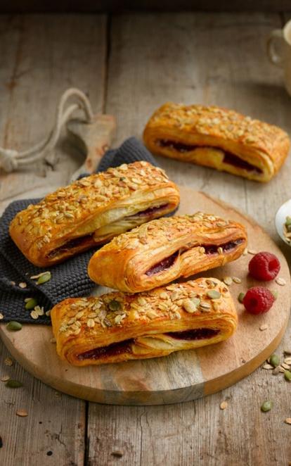 Deze lange suisse is gevuld met frambozen en gedecoreerd met een rijkelijke granolatopping bestaande uit havermout, zaden en pitten