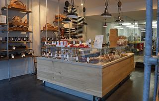 De winkel is zeer open ingericht, met een centrale toonbank waar je volledig rond kunt, en een open atelier achteraan in de winkel