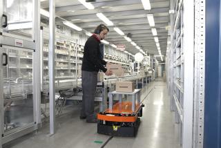 Deze AGV volgt een magneetstrip op de vloer en krijgt onderweg opdrachten via de vloermarkeringen naast de tape