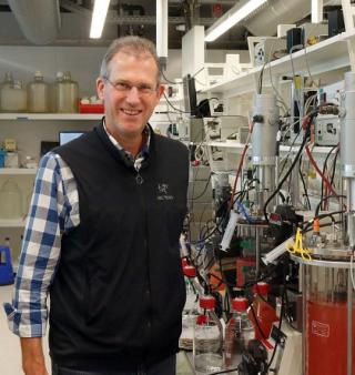 Prof. Mike Jetten in het lab in het Huygensgebouw van de Radboud Universiteit; de rode kleur in de anammoxreactor wordt veroorzaakt door het hoge ijzergehalte