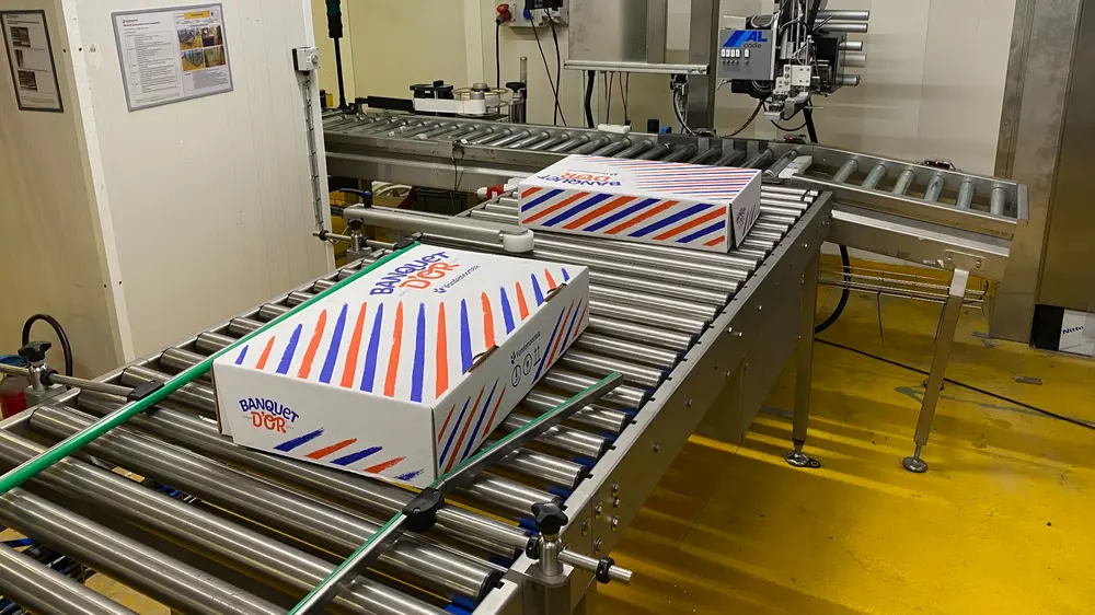 Nadat de plakken deeg in dozen werden gestapeld, gaan die naar een palletizer