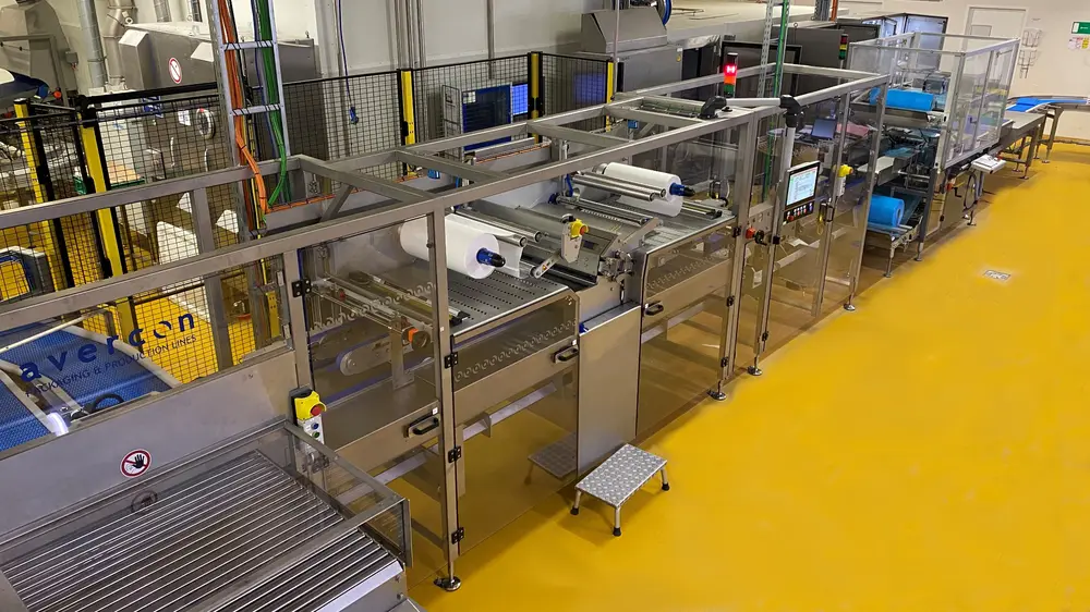 De plakken deeg worden afzonderlijk aangevoerd en op elke plak komt er een folie terecht, waarna ze gestapeld worden afgevoerd