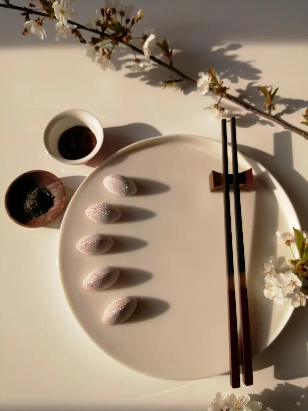 Interne opbouw Onderaan vinden we een crunch van sesam met cashewnoot, gevolgd door een crème van kers. De toplaag is een creamy gel van limoen met saffraan. Om deze laatste te bekomen maakte ik geen gebruik van een traditionele toevoeging zoals agar-agar, gelatine,... en toch werd het gewenste resultaat bereikt.  Zout, zuur, zoet….alles komt aan bod en is in balans met elkaar. De vullingen zijn complementair, geen enkele dominant, en bovendien heeft elk van hen een andere structuur. De extra\'s die erbij worden gegeven maken het geheel af en zorgen voor een extra smaak, umami. De chocolade die werd gebruikt is een Venezolaanse donkere chocolade. Op deze manier komt ook het bittere, kruidige en fruitige naar boven.  Coating Ik heb niet gekozen voor een glanzende buitenkant, maar voor een matte/velours coating. De kleuren zijn een ode aan de kleuren van de Japanse vlag, alsook aan de kersenbloesem die we in de dip terugvinden. De coating werd aangebracht met de airbrush.   Decoratie De dip en gomashio die erbij worden geserveerd maken het geheel af, en zorgen voor een verrassende wending. Zo bekomen we een elegante praline met een extra dimensie.  De dip is gebaseerd op de Japanse saus ‘Tonkatsu’. Echter, kersenbloesem, symbool voor Japan, mocht in dit geheel niet ontbreken en werd dus mee in deze dip verwerkt. De gomashio zorgt nog voor een extra crunchy toets. Just dip it!  Concept Less is more, de chopsticks en 2 toevoegingen, zijn een leuke twist en laten de praline toch nog de hoofdrol spelen. Pralines eten wordt door deze extra’s een beleving, iets uniek en ongezien.  De benaming, JUST DIP IT spreekt voor zich. Deze eerste versie, \'Sushi style\', kan gevolgd worden door tal van varianten. Old school, the African way, the crazy one,….om maar enkele voorbeelden te noemen. Elke variant kan worden voorzien van een bijhorende dip en een leuke twist.  JUST DIP IT!!