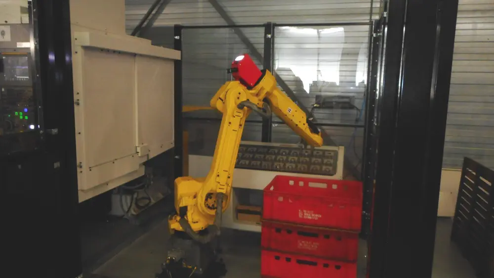 Naast één machine staat een beladingsrobot