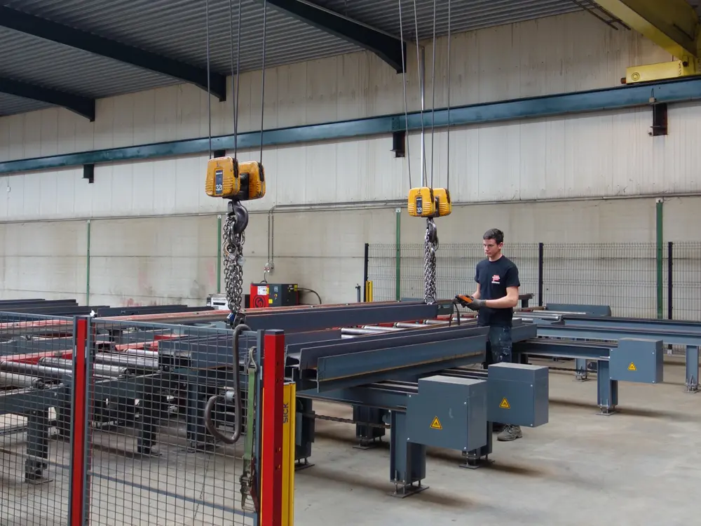 Voorheen werkte FAVEERE met kettingen en klemmen die manueel op het profiel werden bevestigd. Daarbij moest de operator zich tussen de profielen begeven voor het laden en lossen.