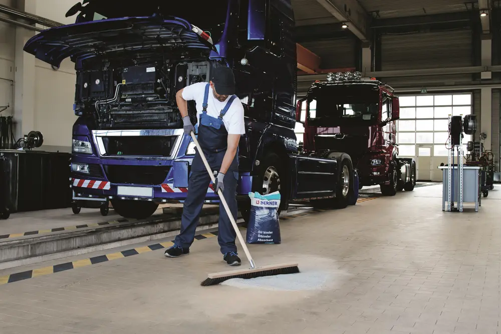 Man veegt garagevloer op