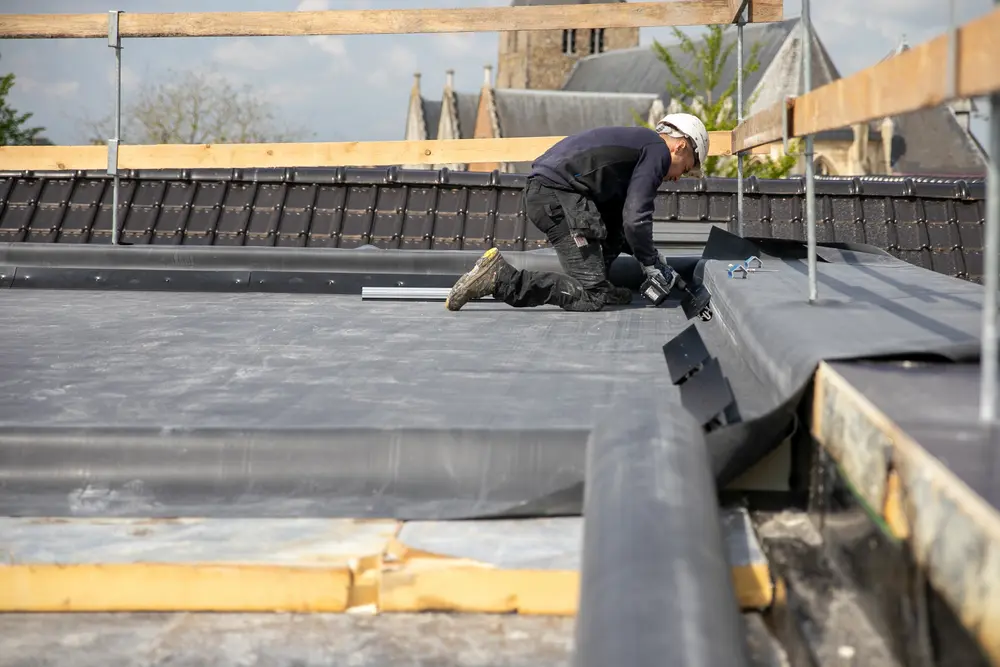 l'isolation est mise sur le toit d'une école