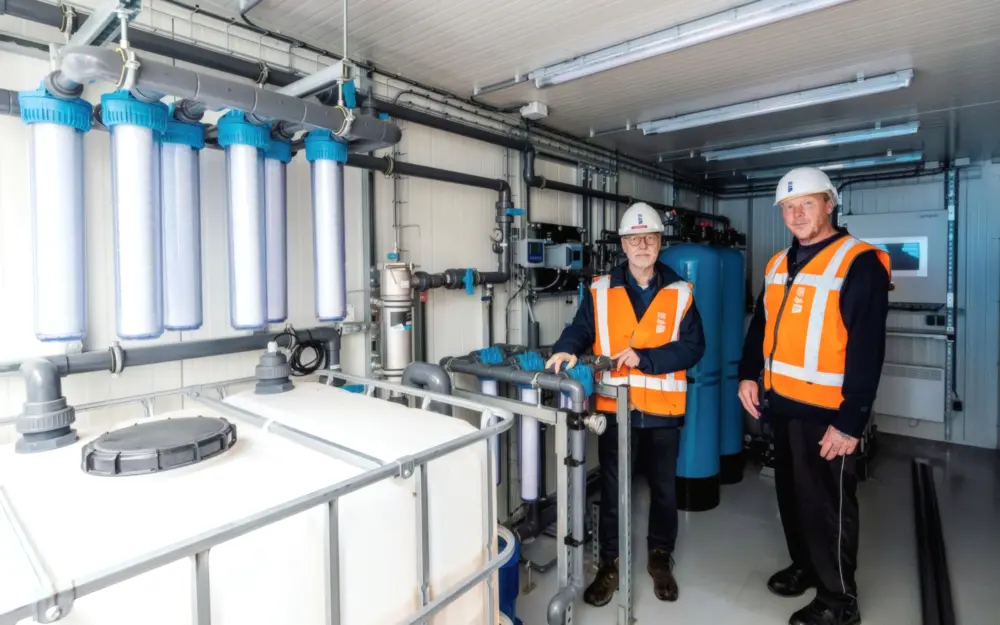 Heemraad Anne Mollema (links) en procesoperator Rob Bakker  inspecteren de juist gearriveerde container met de DEXSORB-filterinstallatie