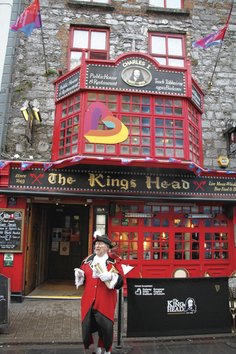 De stadsheraut nodigt uit voor een glas Guinness in een van de typische pubs, The King's Head.