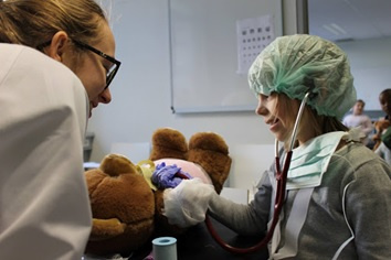 Teddy Bear Hospital. Kinderen verzorgen samen met studenten geneeskunde hun 'zieke' knuffel.