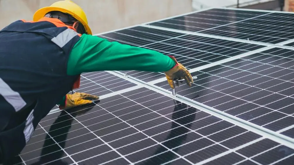 man installeert zonnepanelen