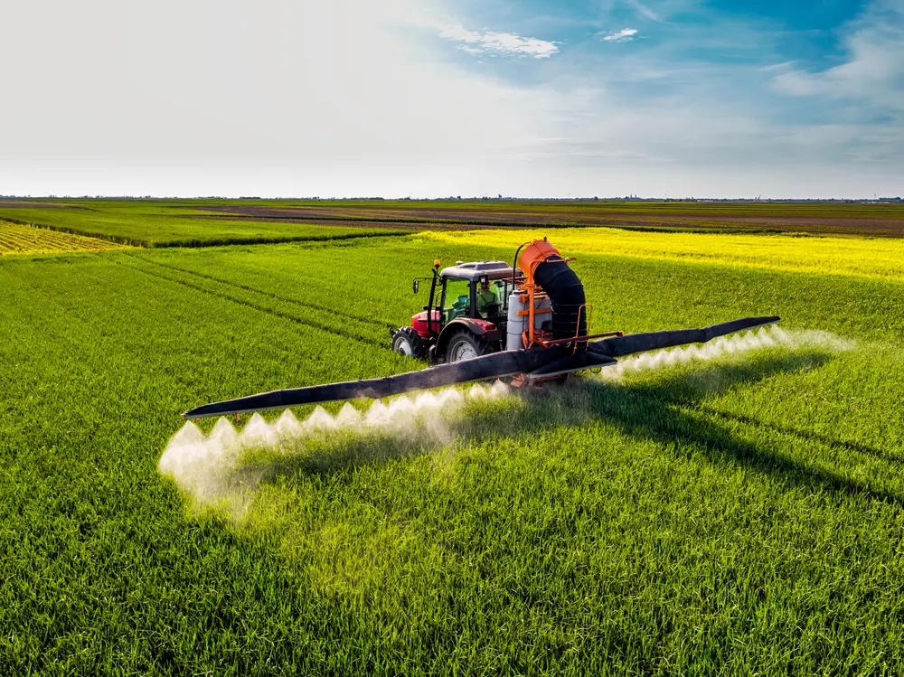 Tracteur pulvérisant un champ