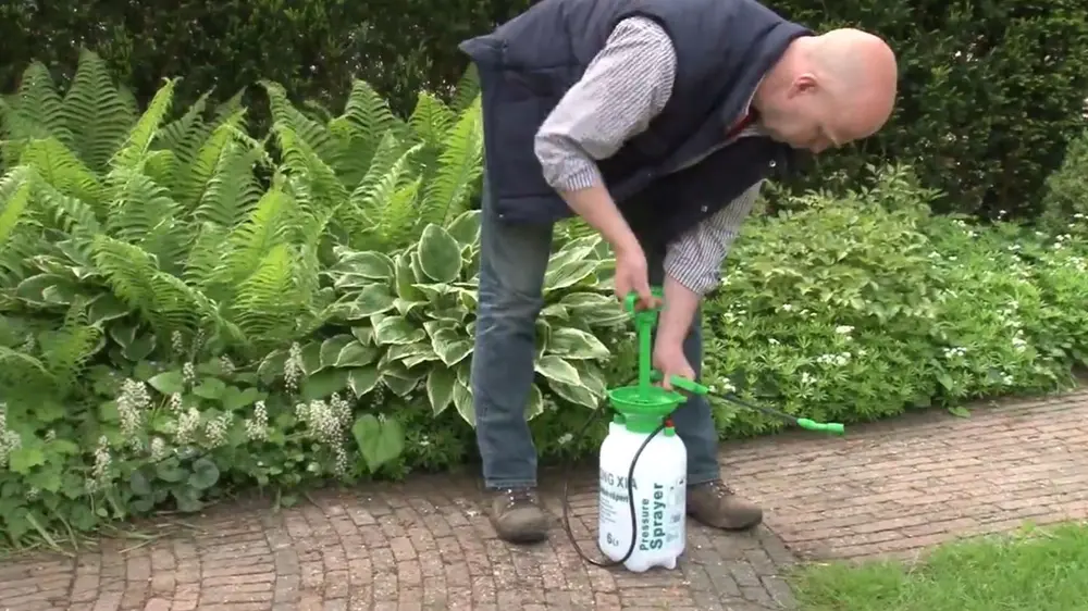man gebruikt drukspuit