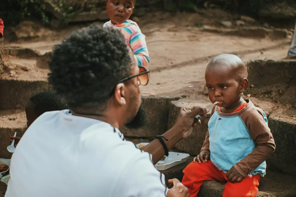 Homme donne à manger à un enfant