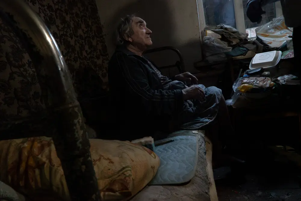 Ancien enseignant aujourd’hui en situation d’invalidité, Oleksander, 67 ans, vit seul dans un village situé à 15 km de la ligne de front.  Il souffre d’une atrophie musculaire marquée des membres inférieurs, associée à d’importants œdèmes distaux.  Bezruky, Ukraine. © Caroline Thirion