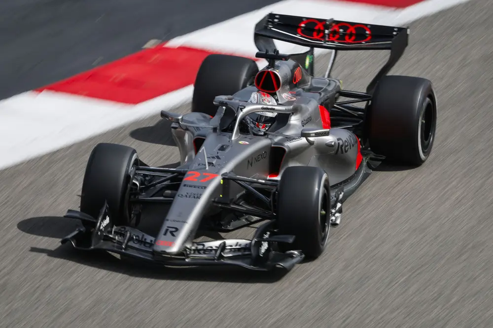 Waar voorheen de DRS enkel de achtervleugel beperkt opende voor inhaalacties, zijn hier de actuatoren zichtbaar die de vleugels kunnen aansturen naar de zogenaamde X-mode. Nu staan beide vleugels in Z-mode (gesloten). Op de voorvleugel zie je twee separate actuatoren aan beide zijden van de neus (bij de ‘v’ van Revolut). Achteraan staat de actuator op dezelfde plaats als waar de DRS-actuator zat, in het midden van het Audi-logo. Let ook op de enorm smalle en bijzonder vormgegeven sidepods