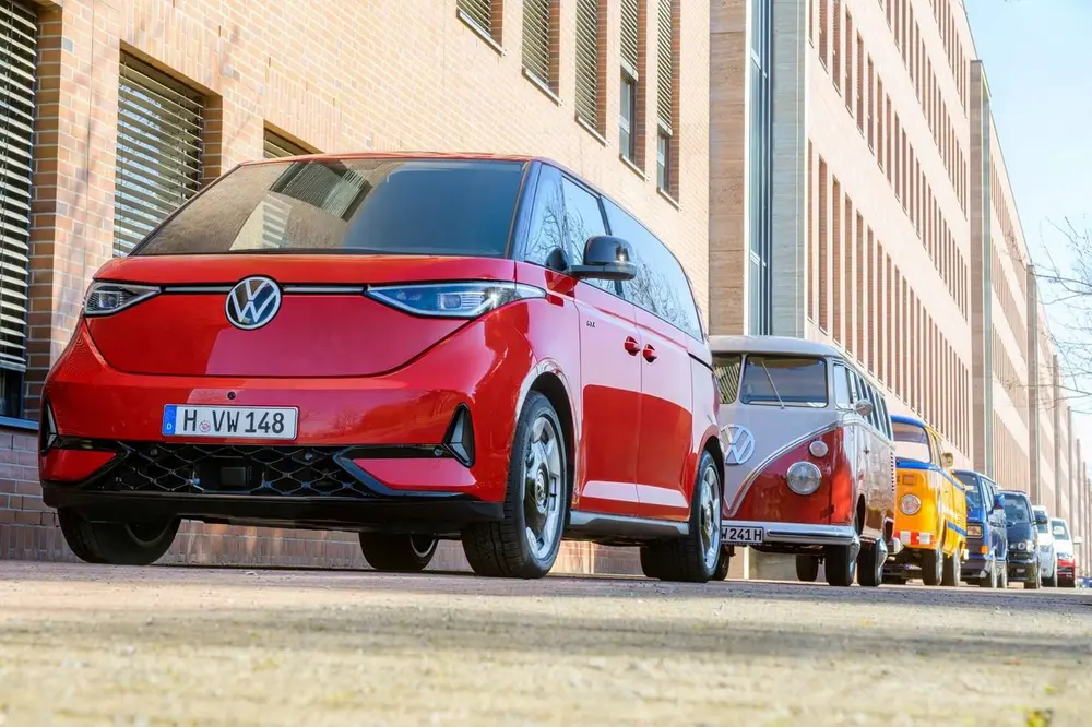 De nieuwste generatie VW Bus naast zijn iconische voorgangers: de volledig elektrische ID. Buzz staat symbool voor de transformatie van de fabriek in Hannover, waar al zeven generaties van de VW Bus werden gebouwd