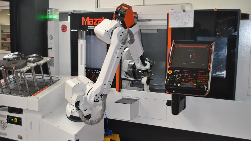 Een voorbeeld van nieuwe bewerkingsmogelijkheden is de MAZAK die is uitgerust met een Robojob-robot met dubbele grijper en uitgerust met een laad- en ontlaadtafel